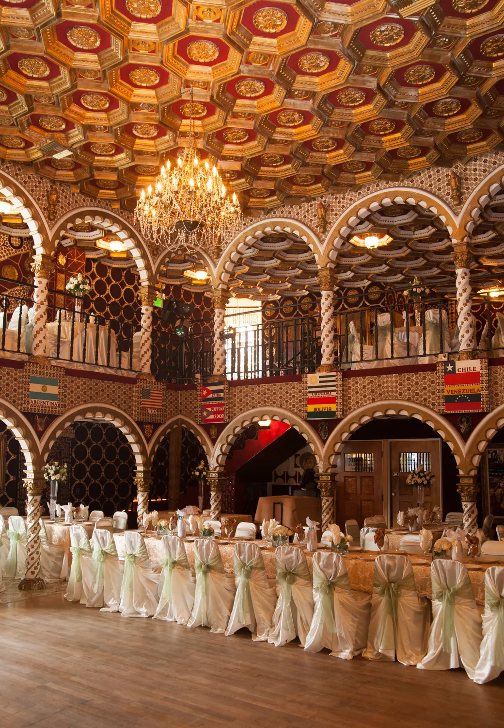 The arched hall from above, rows of white-draped chairs beneath the ornate ceiling.