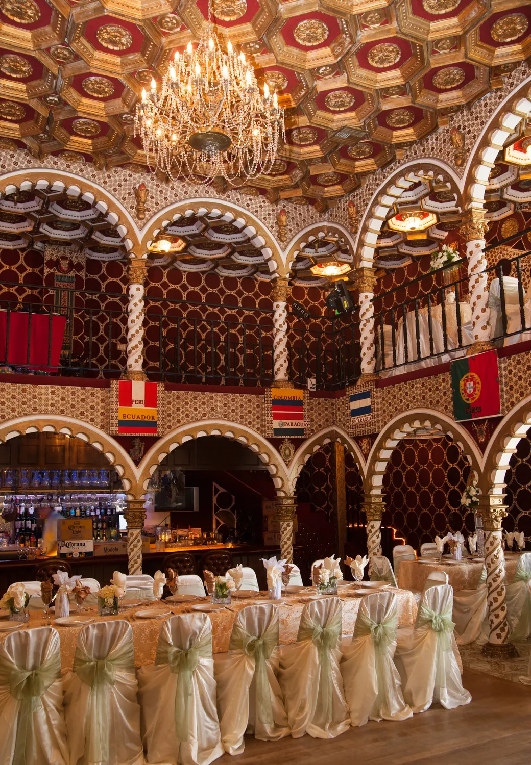 The amber-lit ballroom from the floor, arches and ornate ceiling glowing overhead.