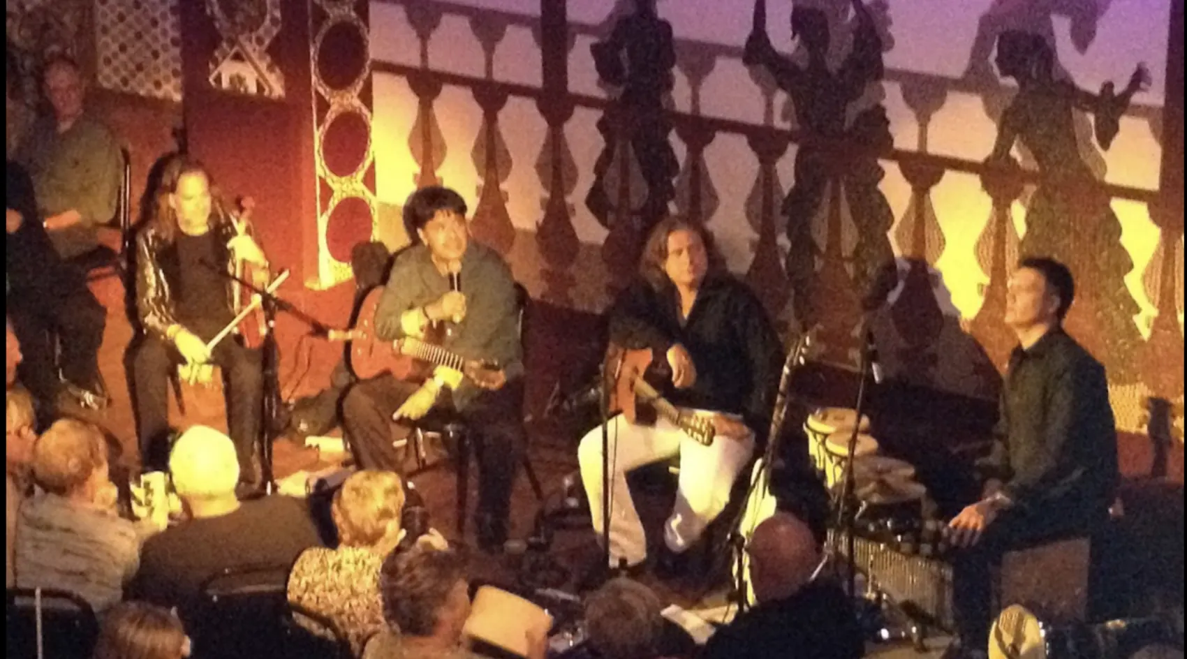 A live band playing on stage in warm amber light.