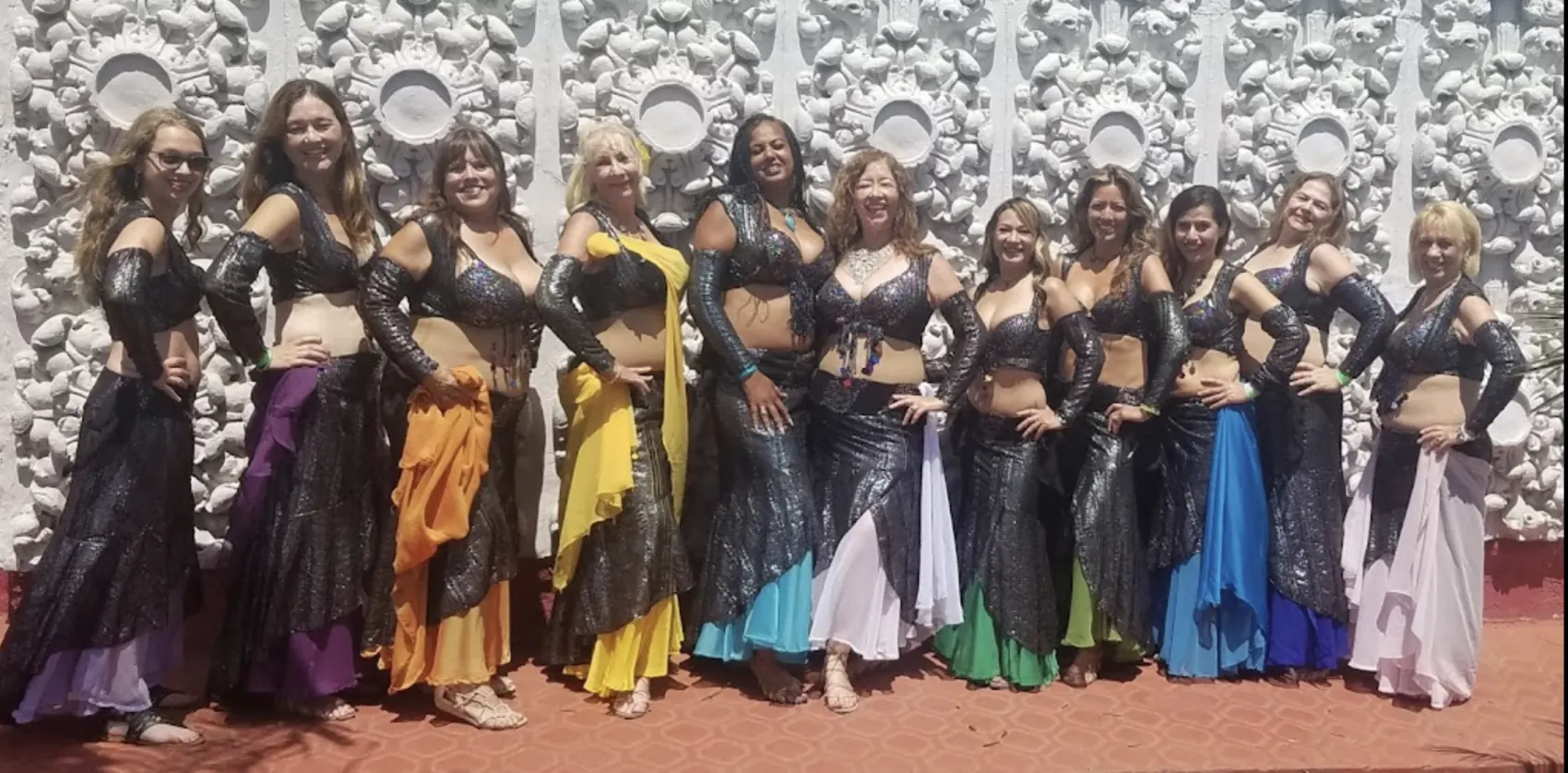 A belly-dance troupe lined up in costume across the stage.