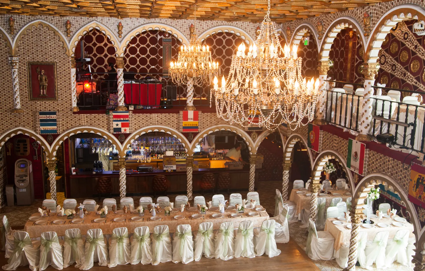 A crystal chandelier hanging between the ballroom's horseshoe arches over set banquet tables.