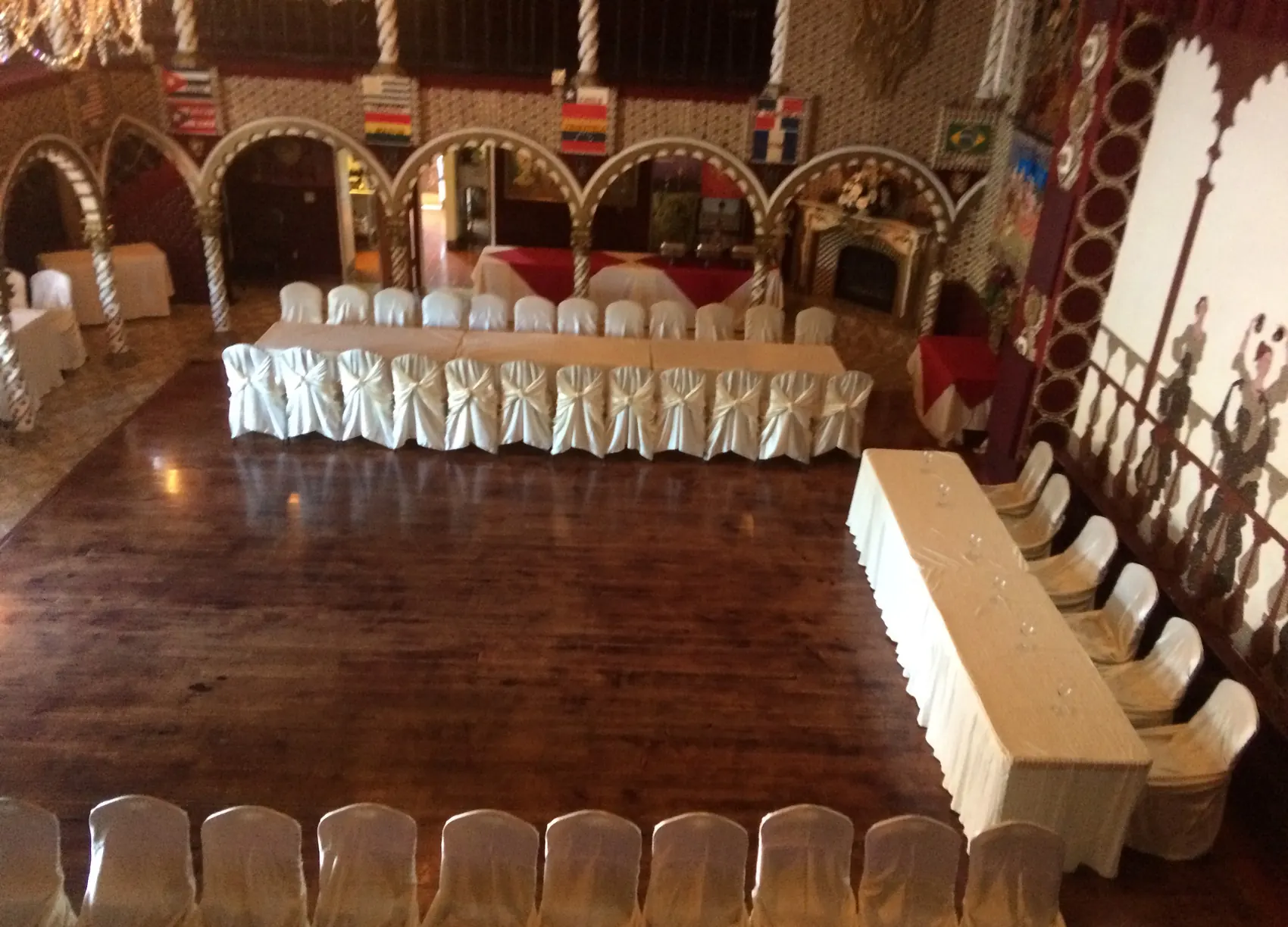 The two-level wood dance floor ringed by set head tables, ready for an event.