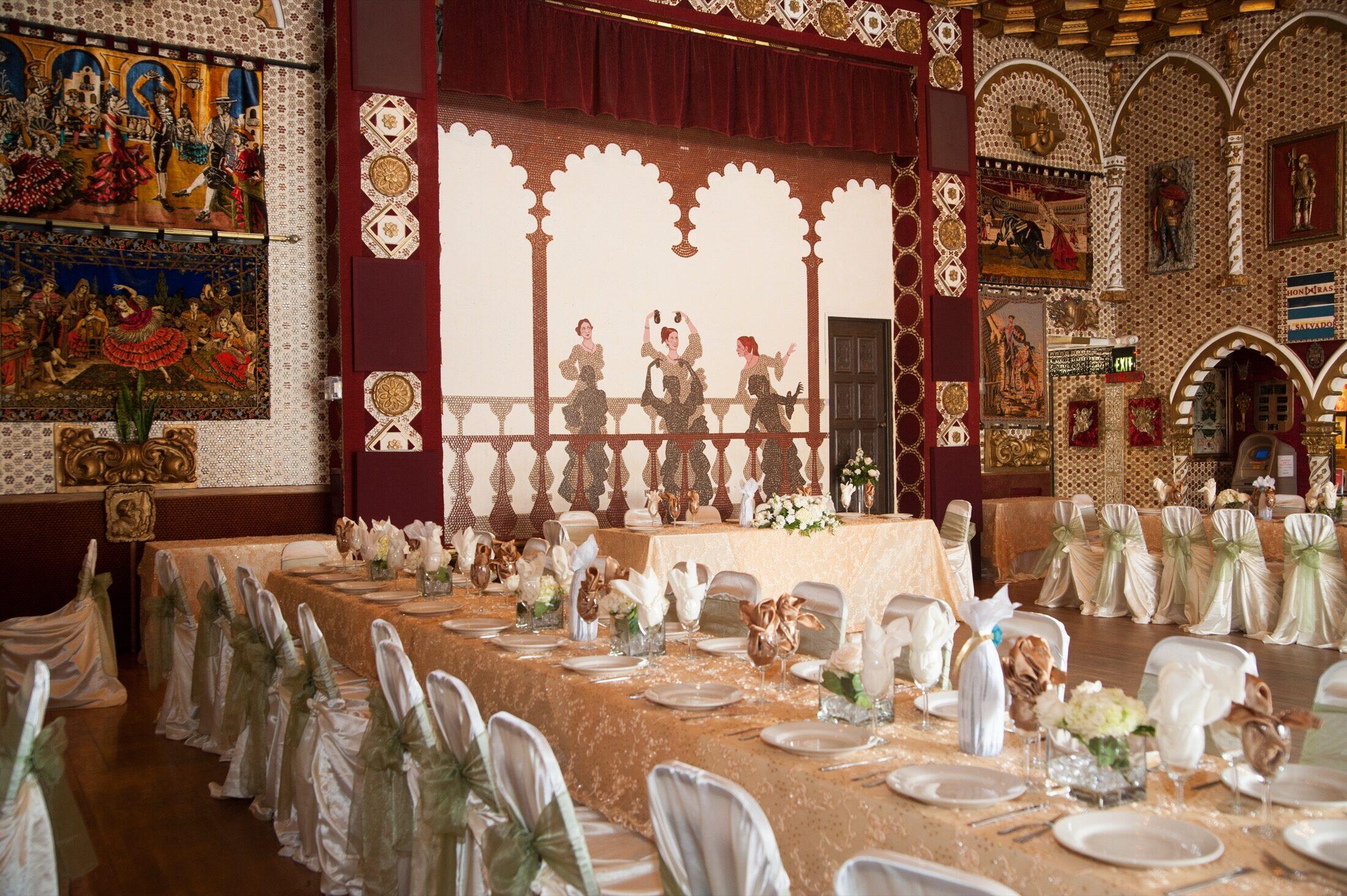 A decorated head table framed by relief work and arches.
