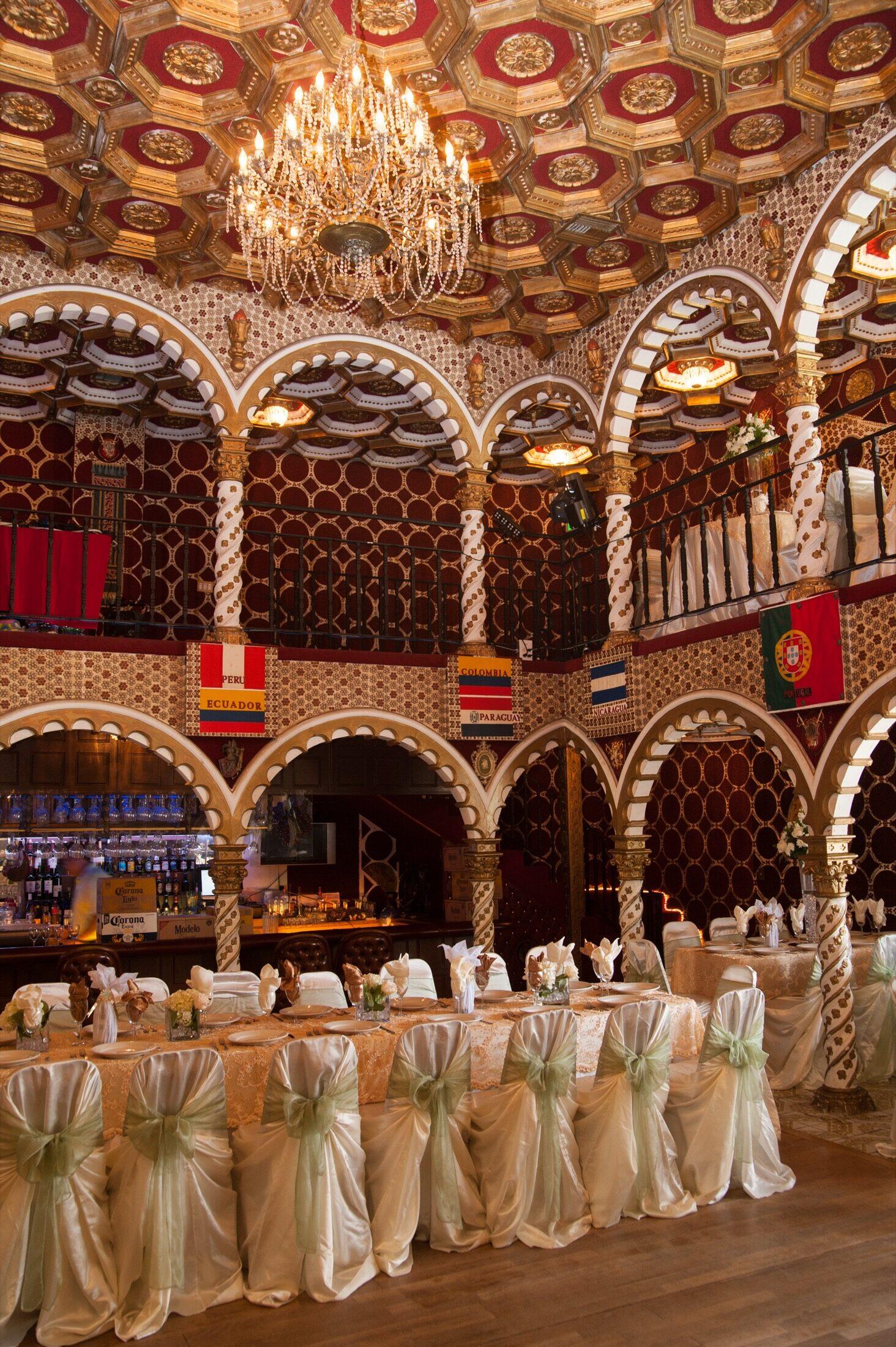 A head table set beneath the ornate ballroom ceiling.